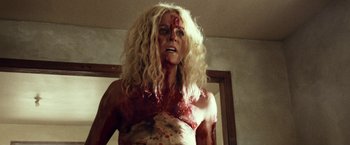 Movie still from “31” (2016), directed by Rob Zombie – A woman with blonde hair and a bloody face; Medium shot, Low angle
