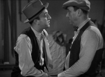 Movie still from “42nd Street” (1933), directed by Lloyd Bacon – A couple of men standing next to each other; Medium shot, Over the shoulder angle