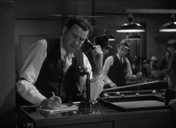 Movie still from “42nd Street” (1933), directed by Lloyd Bacon – A group of men sitting at a table in a room; Medium shot, High angle