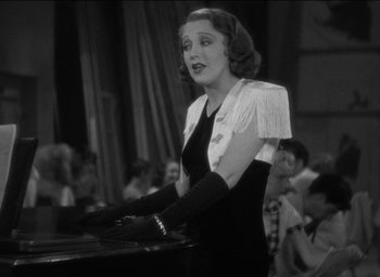 Movie still from “42nd Street” (1933), directed by Lloyd Bacon – An old photo of a woman in a black and white photo; Medium shot, Low angle