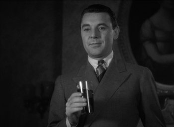 Movie still from “42nd Street” (1933), directed by Lloyd Bacon – A black and white photo of a man in a suit and tie holding a drink; Close Up shot, Low angle