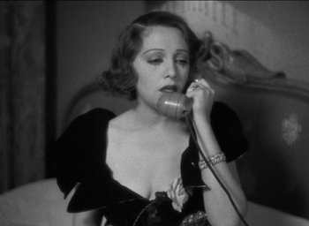 Movie still from “42nd Street” (1933), directed by Lloyd Bacon – A woman talking on a phone while wearing a black dress; Close Up shot, Low angle