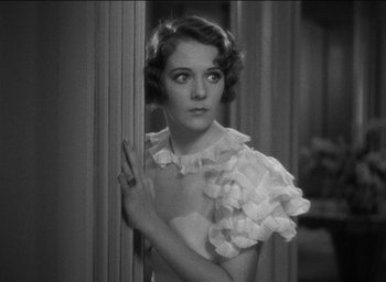 Movie still from “42nd Street” (1933), directed by Lloyd Bacon – An old photo of a woman in a white dress; Close Up shot, High angle
