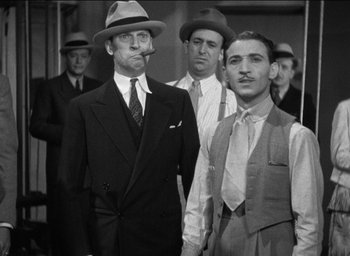 Movie still from “42nd Street” (1933), directed by Lloyd Bacon – A black and white photo of men in suits and hats; Medium shot, Low angle