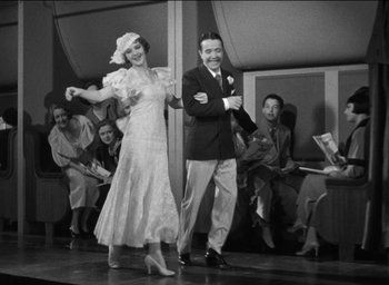 Movie still from “42nd Street” (1933), directed by Lloyd Bacon – A man and a woman are dancing in front of a crowd; Medium shot, Low angle