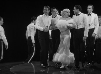 Movie still from “42nd Street” (1933), directed by Lloyd Bacon – A group of men standing next to each other; Wide shot, Low angle