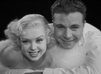 Movie still from “42nd Street” (1933), directed by Lloyd Bacon – A man and a woman posing for a picture; Close Up shot, Low angle