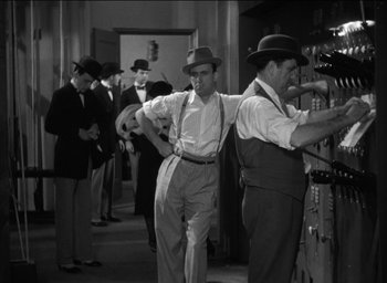 Movie still from “42nd Street” (1933), directed by Lloyd Bacon – A black and white photo of a group of men in hats; Medium shot, Low angle