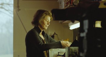 Movie still from “45 Years” (2015), directed by Andrew Haigh – An older woman in a black shirt is working on a project; Medium shot, Low angle