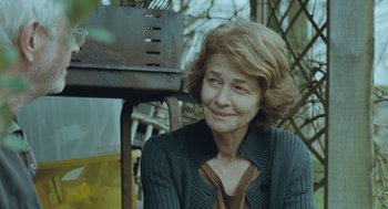 An older woman sitting in front of an old fire hydrant