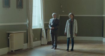 Movie still from “45 Years” (2015), directed by Andrew Haigh – A man and a woman are standing in a room; Wide shot, Low angle
