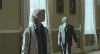Movie still from “45 Years” (2015), directed by Andrew Haigh – A woman standing next to a man wearing a suit; Medium shot, Over the shoulder angle