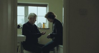 Movie still from “45 Years” (2015), directed by Andrew Haigh – Two people sitting in a bathroom talking to each other; Medium shot, Over the shoulder angle