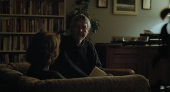 Movie still from “45 Years” (2015), directed by Andrew Haigh – An older man sitting on a couch with a woman; Medium shot, Over the shoulder angle