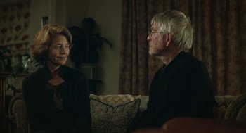Movie still from “45 Years” (2015), directed by Andrew Haigh – A man and a woman sitting in a living room talking; Medium shot, Over the shoulder angle