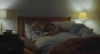 Movie still from “45 Years” (2015), directed by Andrew Haigh – An older man and a woman laying in a bed together; Medium shot, High angle