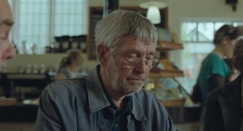 Movie still from “45 Years” (2015), directed by Andrew Haigh – An older man with white hair wearing glasses; Close Up shot, Over the shoulder angle