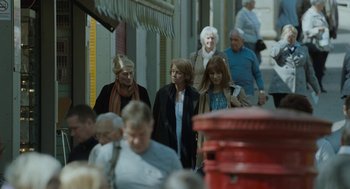 Movie still from “45 Years” (2015), directed by Andrew Haigh – A group of people walking down a street; Wide shot, Over the shoulder angle