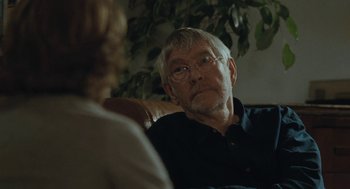 Movie still from “45 Years” (2015), directed by Andrew Haigh – An older man sitting on a couch talking to a younger woman; Close Up shot, Over the shoulder angle