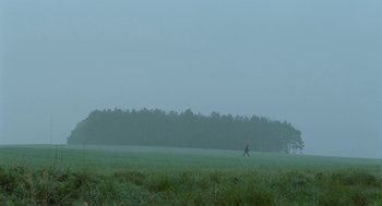 Movie still from “45 Years” (2015), directed by Andrew Haigh – A person is walking in a field in the fog; Extreme Wide shot, Low angle