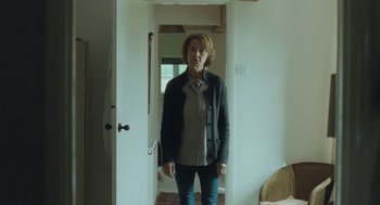 Movie still from “45 Years” (2015), directed by Andrew Haigh – A woman standing in front of an open door; Medium shot, Low angle