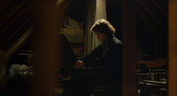 Movie still from “45 Years” (2015), directed by Andrew Haigh – A woman sitting at a piano in a dark room; Medium shot, High angle