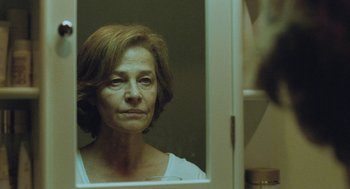Movie still from “45 Years” (2015), directed by Andrew Haigh – An older woman looking in the mirror in front of a bathroom mirror; Close Up shot, Over the shoulder angle