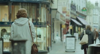 Movie still from “45 Years” (2015), directed by Andrew Haigh – A woman is walking down the street with a bag; Wide shot, Over the shoulder angle