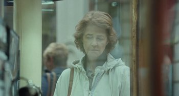 Movie still from “45 Years” (2015), directed by Andrew Haigh – A woman looking out of a window at a building; Close Up shot, Over the shoulder angle
