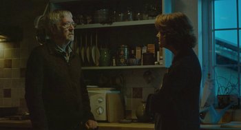 Movie still from “45 Years” (2015), directed by Andrew Haigh – A man and a woman standing in front of a kitchen counter; Medium shot, Over the shoulder angle