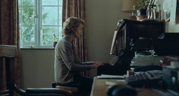 Movie still from “45 Years” (2015), directed by Andrew Haigh – A man playing a piano in a living room; Medium shot, Over the shoulder angle