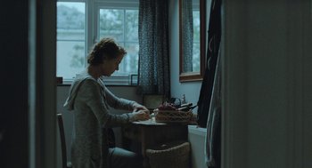 Movie still from “45 Years” (2015), directed by Andrew Haigh – A woman sitting at a table in front of a window; Medium shot, Over the shoulder angle