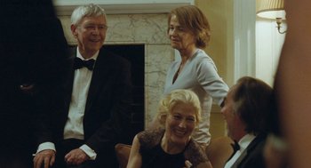 Movie still from “45 Years” (2015), directed by Andrew Haigh – A group of people sitting in a room together; Medium shot, Over the shoulder angle