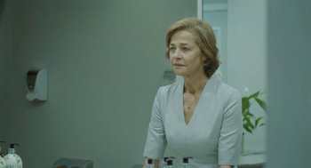 Movie still from “45 Years” (2015), directed by Andrew Haigh – An older woman in a white dress looking at a mirror; Medium shot, Over the shoulder angle