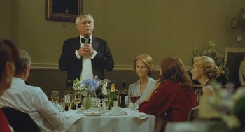 Movie still from “45 Years” (2015), directed by Andrew Haigh – A group of people sitting at a table with wine glasses; Medium shot, Over the shoulder angle