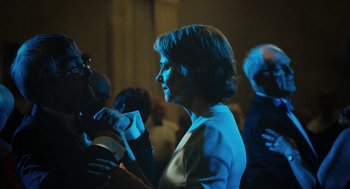 Movie still from “45 Years” (2015), directed by Andrew Haigh – A woman standing next to a group of people; Medium shot, Over the shoulder angle