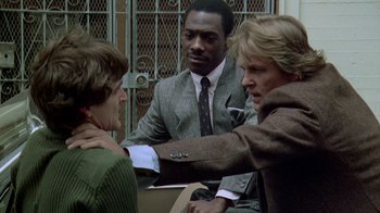Movie still from “48 Hrs.” (1982), directed by Walter Hill – A group of people sitting around a table; Close Up shot, Over the shoulder angle
