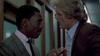 Movie still from “48 Hrs.” (1982), directed by Walter Hill – Two men talking to each other in front of a wall; Close Up shot, Over the shoulder angle