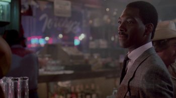 Movie still from “48 Hrs.” (1982), directed by Walter Hill – A man standing in front of a bar at night; Close Up shot, Over the shoulder angle
