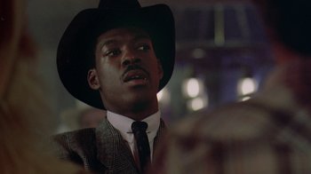 Movie still from “48 Hrs.” (1982), directed by Walter Hill – A man wearing a suit and a cowboy hat; Close Up shot, Low angle