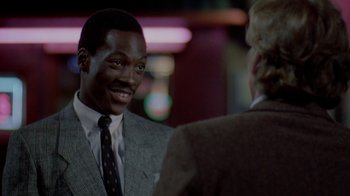 Movie still from “48 Hrs.” (1982), directed by Walter Hill – A man wearing a suit and tie talking to another man wearing a suit and tie; Close Up shot, Over the shoulder angle