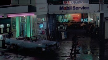 Movie still from “48 Hrs.” (1982), directed by Walter Hill – A man sweeping the floor of an abandoned car shop; Extreme Wide shot, High angle