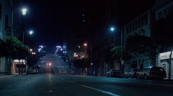 Movie still from “48 Hrs.” (1982), directed by Walter Hill – A city street at night lit up by streetlights; Extreme Wide shot, Low angle