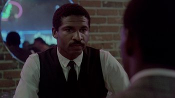 Movie still from “48 Hrs.” (1982), directed by Walter Hill – A man in a vest and tie talking to another man; Close Up shot, Over the shoulder angle