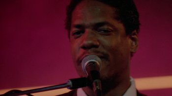 Movie still from “48 Hrs.” (1982), directed by Walter Hill – A person singing on a microphone; Close Up shot, Low angle