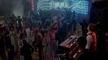 Movie still from “48 Hrs.” (1982), directed by Walter Hill – A group of people standing in a room with a piano; Extreme Wide shot, High angle