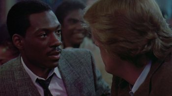 Movie still from “48 Hrs.” (1982), directed by Walter Hill – A man wearing a suit and tie talking to another man wearing a suit and tie; Close Up shot, Over the shoulder angle