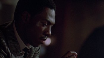 Movie still from “48 Hrs.” (1982), directed by Walter Hill – A person wearing a suit and tie; Close Up shot, Over the shoulder angle