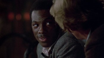 Movie still from “48 Hrs.” (1982), directed by Walter Hill – A man in a plaid jacket talking to another man in a plaid jacket; Close Up shot, Over the shoulder angle