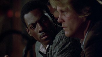 Movie still from “48 Hrs.” (1982), directed by Walter Hill – Two men in suits are looking at each other; Close Up shot, Over the shoulder angle